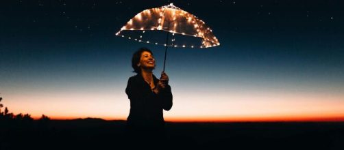 Donna con ombrello in una notte stellata (©pexels.com)