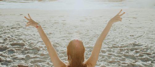 Donna di spalle in spiaggia © Pexels