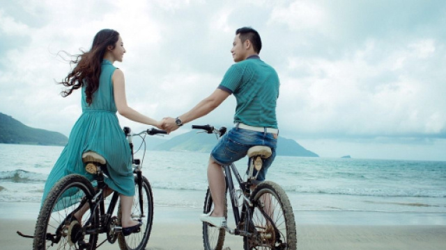 Una coppia che va in bici sulla spiaggia © Pixabay