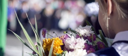 Una ragazza con dei fiori in mano (©pixabay.com)