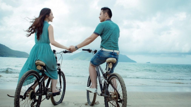 Una coppia che va in bici sulla spiaggia © Pixabay.