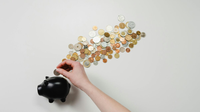 Mano che mette le monete dentro il salvadanaio © Pexels.