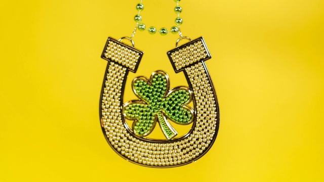 Ciondolo con ferro di cavallo e quadrifoglio, simboli di fortuna © Pexels.