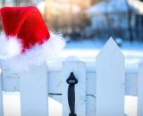 Cappello di Babbo Natale su una staccionata bianca (©pixabay.com)