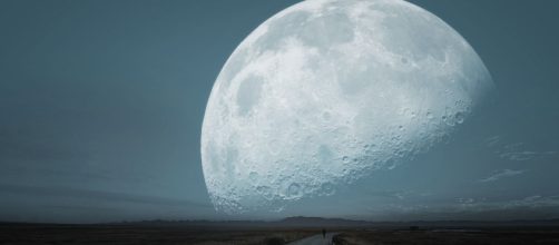 Uomo che cammina su una strada con una Luna gigante sullo sfondo © pixabay.com