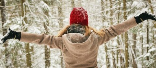 Ragazza nella neve con un cappello rosso © Pexels