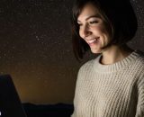 Donna al pc sotto ad un cielo stellato - © Gemini AI