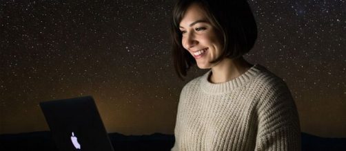 Donna al pc sotto ad un cielo stellato - © Gemini AI