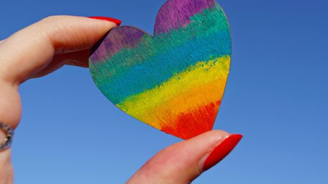 Un cuore arcobaleno nelle mani di una ragazza © Pexels