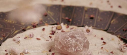 Carte dei tarocchi coperte con quarzo rosa-© Pexels.