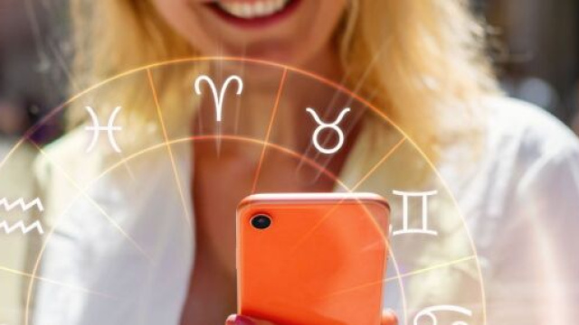 Donna con cellulare e ruota dei segni zodiacali - Foto da &copy; Pixabay.