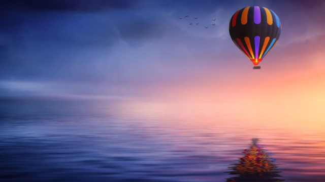 Mongolfiera colorata sul mare al tramonto - © Pixabay.
