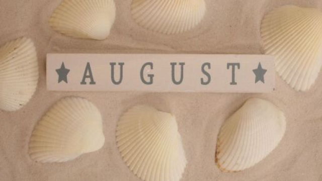Conchiglie con sabbia e scritta August © Immagine di Pixabay.
