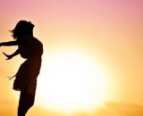 Figura femminile in atteggiamento sereno con Sole sullo sfondo - © Pixabay IA.