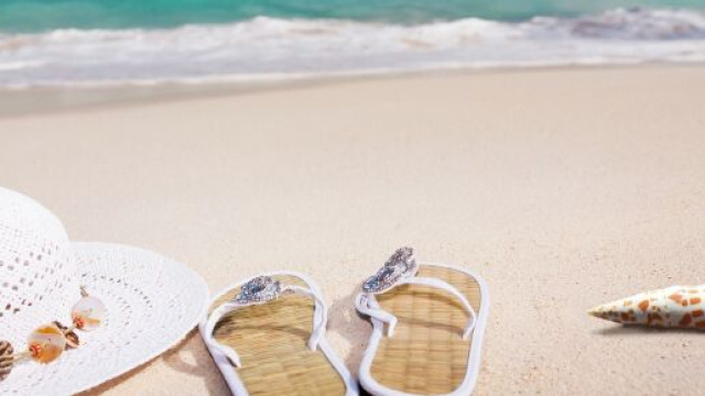 Cappellino bianco con ciabatte e conchiglia sulla spiaggia - © Pixabay.