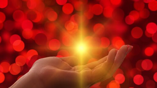 Mano aperta con luce brillante, simbolo di spiritualità e benedizione — © Pixabay IA.