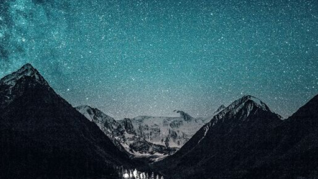 Un cielo pieno di stelle sopra montagne innevate &copy; Pixabay.