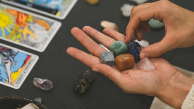 Tarocchi e mani con pietre minerali-© Pexels.