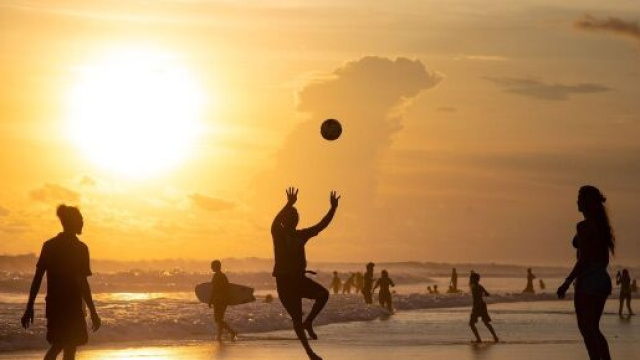 Ragazzi che giocano in spiaggia al tramonto (©pixabay)