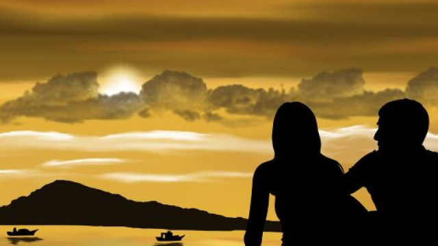 Coppia osserva il tramonto sul lago con montagne all’orizzonte – © Pixabay IA.